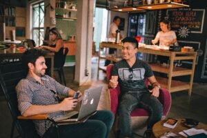 image of 2 people working on a laptop in a coffeeshop